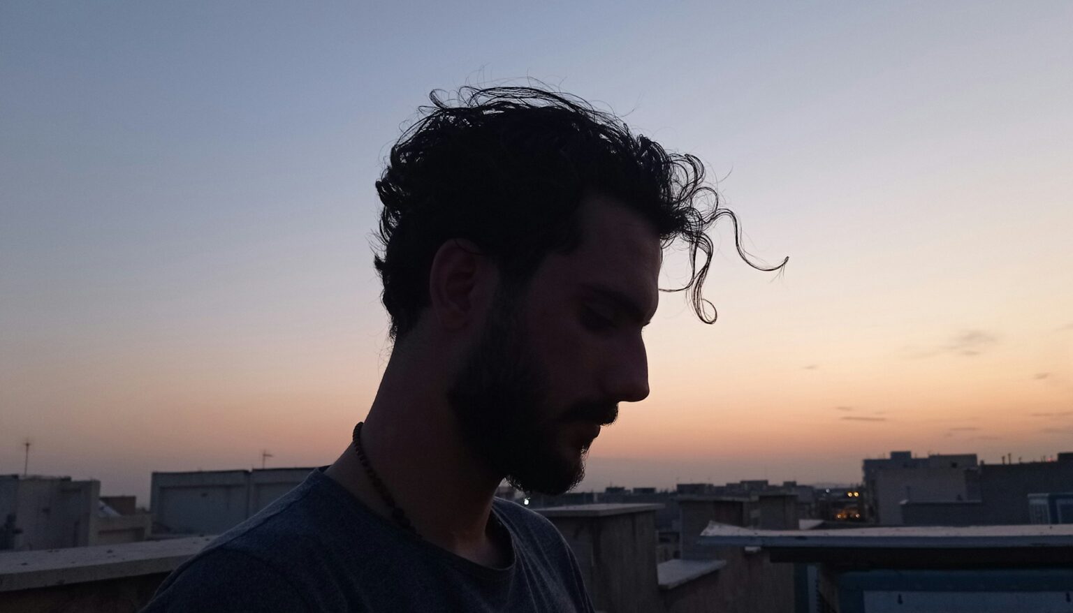 Silhouette eines Mannes mit vollem Haar bei Sonnenuntergang