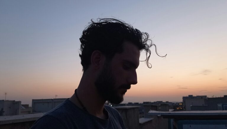 Silhouette eines Mannes mit vollem Haar bei Sonnenuntergang